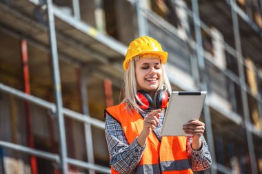 Tablet kullanan mimar kadın inşaat alanında mutlu ve sanayi, planlama ve teftiş.