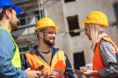 İnşaat ekibi inşaat alanında mimari yenilikler için işbirliği içeren bir proje planlıyor. Mimari, tasarım ve mühendisler başarılı olmak için takım çalışmasına sahipler. 