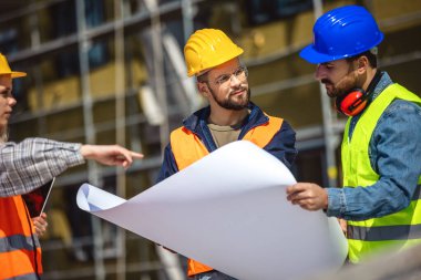 İnşaat ekibi inşaat alanında mimari yenilikler için işbirliği içeren bir proje planlıyor. Mimari, tasarım ve mühendisler başarılı olmak için takım çalışmasına sahipler. 