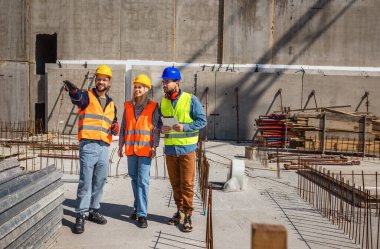 İnşaat ekibi inşaat alanında mimari yenilikler için işbirliği içeren bir proje planlıyor. Mimari, tasarım ve mühendisler başarılı olmak için takım çalışmasına sahipler. 