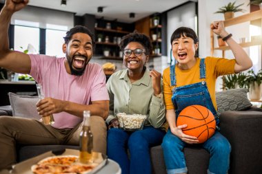 Basketbol maçı izleyen, pizza yiyen, bira içen ve tezahürat yapan çok ırklı bir arkadaş grubu..