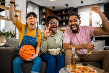 Basketbol maçı izleyen, pizza yiyen, bira içen ve tezahürat yapan çok ırklı bir arkadaş grubu..