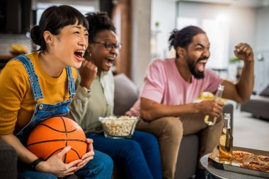 Basketbol maçı izleyen, pizza yiyen, bira içen ve tezahürat yapan çok ırklı bir arkadaş grubu..
