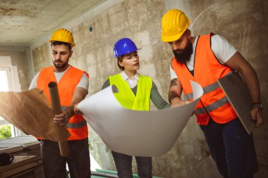 İnşaat ekibi inşaat alanında mimari yenilikler için işbirliği içeren bir proje planlıyor. Mimari, tasarım ve mühendisler başarılı olmak için takım çalışmasına sahipler.