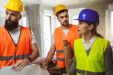 İnşaat ekibi inşaat alanında mimari yenilikler için işbirliği içeren bir proje planlıyor. Mimari, tasarım ve mühendisler başarılı olmak için takım çalışmasına sahipler.