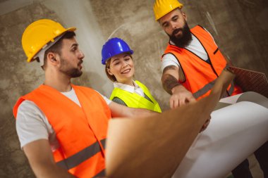 İnşaat ekibi inşaat alanında mimari yenilikler için işbirliği içeren bir proje planlıyor. Mimari, tasarım ve mühendisler başarılı olmak için takım çalışmasına sahipler.