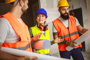 İnşaat ekibi inşaat alanında mimari yenilikler için işbirliği içeren bir proje planlıyor. Mimari, tasarım ve mühendisler başarılı olmak için takım çalışmasına sahipler.