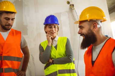 İnşaat ekibi inşaat alanında mimari yenilikler için işbirliği içeren bir proje planlıyor. Mimari, tasarım ve mühendisler başarılı endüstriyel yenileme çalışmaları için takım çalışmasına sahipler.