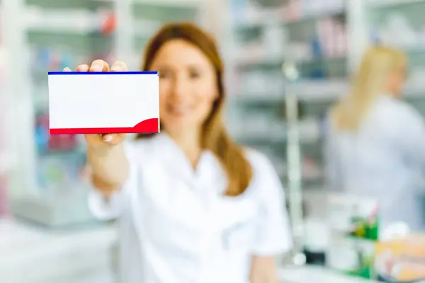 Γυναίκα Φαρμακοποιός Που Κρατάει Ένα Κουτί Φάρμακα Στο Φαρμακείο — Φωτογραφία Αρχείου