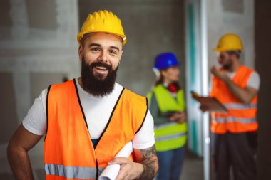 Güvenlik yeleği ve miğfer giymiş inşaat işçisi portresi. 