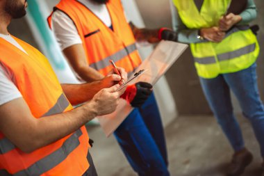 İnşaat ekibi inşaat alanında mimari yenilikler için işbirliği içeren bir proje planlıyor. Mimari, tasarım ve mühendisler başarılı olmak için takım çalışmasına sahipler.