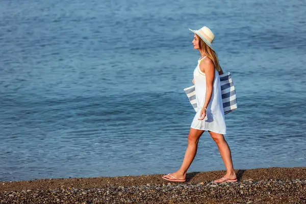 สาวสวยเด นคนเด ยวบนชายหาดก บกระเป าชายหาดและหมวก ภาพถ่ายสต็อกที่ปลอดค่าลิขสิทธิ์