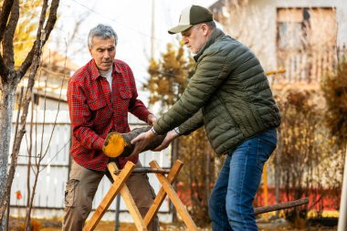 İki oduncu kesilecek bir odun parçası hazırlıyor..