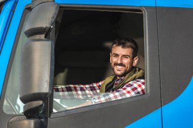 Mavi kamyonetini süren genç kamyon şoförünün portresi..