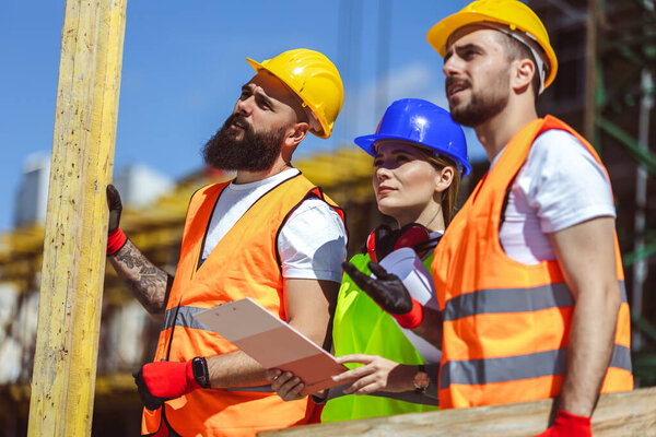 Два строителя, несущие решетки на строительной площадке - люди на рабочих концепциях внутри здания.