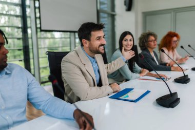 İnsan CEO 'su iş planı ve gelecekteki işbirliği hakkında iş arkadaşlarıyla mikrofonda konuşuyor..