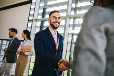 İnsan Kaynakları 'ndan bir işadamı, iş görüşmesinden sonra şirketlerinin yeni Afrikalı Amerikalı çalışanını tebrik ediyor..