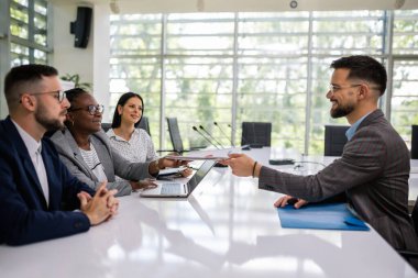 İnsan kaynakları, iş görüşmesi sırasında rahat bir ortamda genç bir erkek başvuru sahibi ile hoş bir konuşma yapıyor..