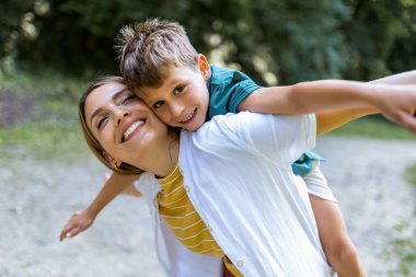 Genç ve güzel anne, oğluyla oynuyordu..