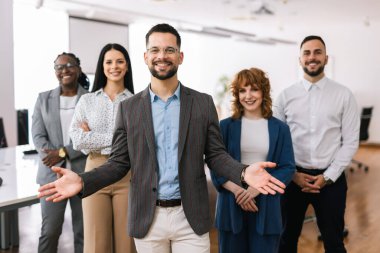 Meslektaşlarının önünde elleri çapraz duran genç CEO 'nun portresi..