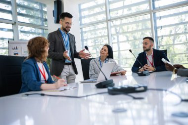 Yönetici iş planı ve gelecekteki işbirliği hakkında iş arkadaşlarıyla toplantıda konuşuyor..
