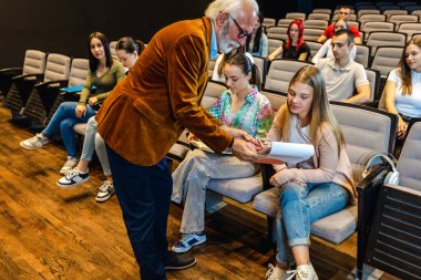 Bir konferansta öğrencilerinin sorularını yanıtlayan yaşlı bir profesör..