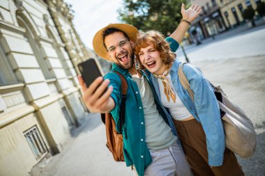 Şehir merkezinde selfie çeken genç bir çift. Seyahat ve keşif konsepti.