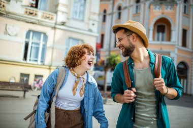 Genç çift tatillerinde eğleniyor. Şehir merkezinde gülümsüyor. Seyahat konsepti.