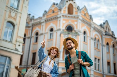 Şehri keşfeden bir çift. Kız arkadaşı erkek arkadaşını gösteriyor.