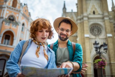Genç bir çift yeni şehri gezmek için bir harita kullanıyor..