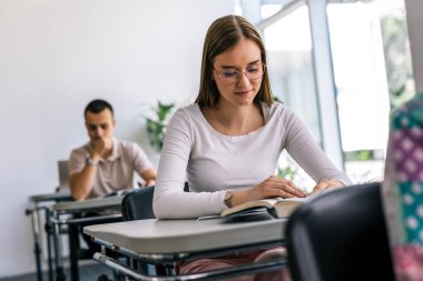 Sınıfta kitap okuyan kız öğrencinin portresi..