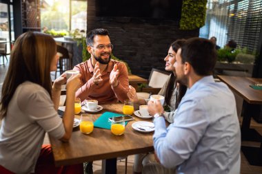 Bir grup arkadaş kafede takılıyorlar, kahve ve portakal suyu içiyorlar..