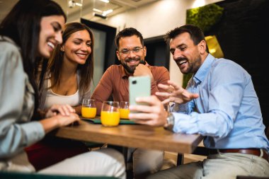 Bir arkadaş grubu kafede buluştu. Telefondaki resimlere bakıyorum. Birlikte eğleniyoruz..