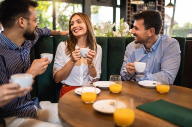 Bir grup arkadaş restoranda takılıyorlar. Gülüyorlar, konuşuyorlar ve kahve içiyorlar..