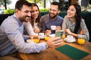 Bir arkadaş grubu kafede buluştu. Telefondaki resimlere bakıyorum. Birlikte eğleniyoruz..