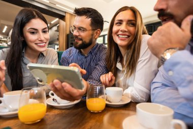Bir arkadaş grubu kafede buluştu. Telefondaki resimlere bakıyorum. Birlikte eğleniyoruz..