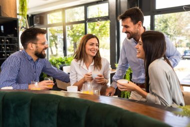 Bir grup arkadaş restoranda buluştu. Takılıyorlar, kahve içip gülüyorlar..