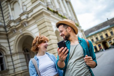 Genç çift, tatilde, yeni şehri keşfediyorlar ve telefonlarını kaybolmamaları için GPS olarak kullanıyorlar..