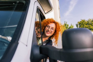 Pencereden dışarı bakan profesyonel kadın kamyon şoförünün portresi. Halk ve endüstriyel ulaşım kavramı.