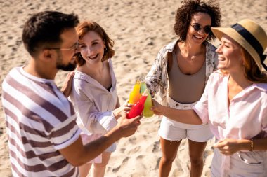 Bir grup arkadaş güneşli bir günde plajda takılıyorlar. Kadeh kaldırır ve alkol içerler.