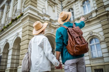 Kızıl kız arkadaşı ve erkek arkadaşı yeni şehri keşfederken el ele tutuşuyorlar ve tatillerinde paralara ve binalara bakıyorlar..