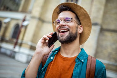 Turist yeni ülkeyi gezerken telefonla konuşuyor.