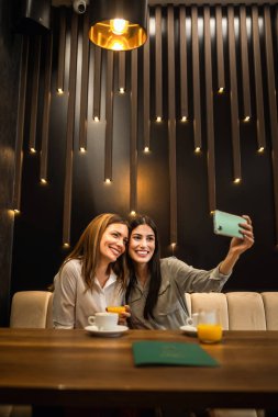 Restoranda selfie çeken iki kız arkadaş. Anı yakalıyorum..