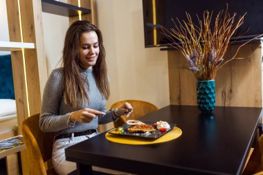 Evindeki neşeli kadın öğle yemeği yiyor ve portakal suyu içiyor..