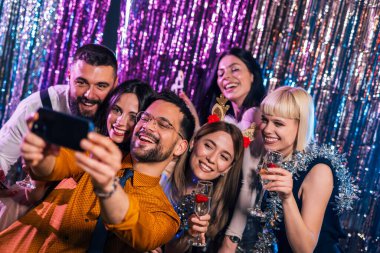 Bir grup arkadaş dışarı çıktıkları gece kulübünde selfie çekiyorlar..