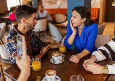 Lokantada fotoğraflarını çeken bir kadın onlara yardım ediyor..