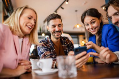 Bir arkadaş grubu kafede buluştu. Telefondaki resimlere bakıyorum. Birlikte eğleniyoruz..