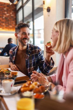 Lokantada birbirini lezzetli yemeklerle besleyen bir çift..