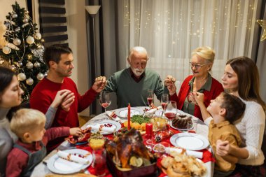 Aile lezzetli ev yemekleri yemeden önce dua eder. Noel yemeği. Noel süslemeleri