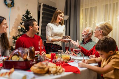 Annem yemek masasına lezzetli bir pasta getirdi. Aile Noel kutlaması.